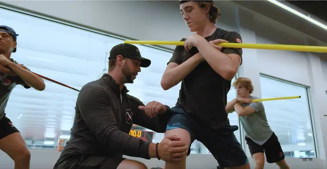 Thumbnail of the Hockey Development Camp video showing a trainer helping an athlete